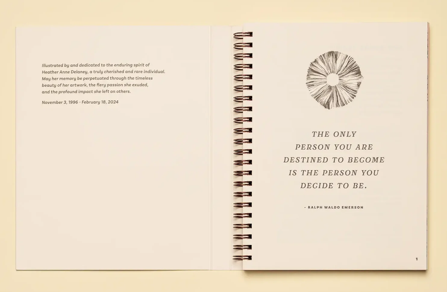 An open spiral-bound notebook on a tan background displaying a Ralph Waldo Emerson quote and a dedication to Heather Anne Delaney